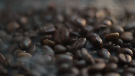 Close-up-macro-time-lapse-of-steaming-coffee-beans-falling,-spilling-onto-the-pile-of-grains