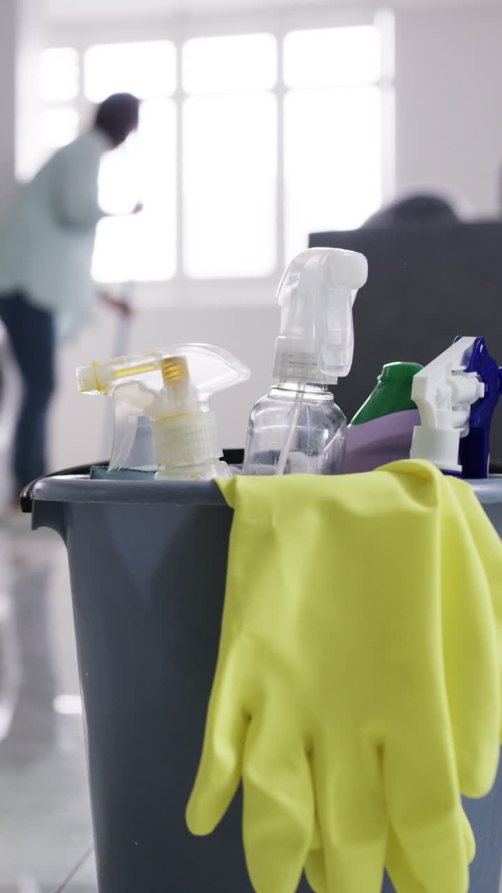 Cleaning Supplies Bucket with Person Tidying in Background