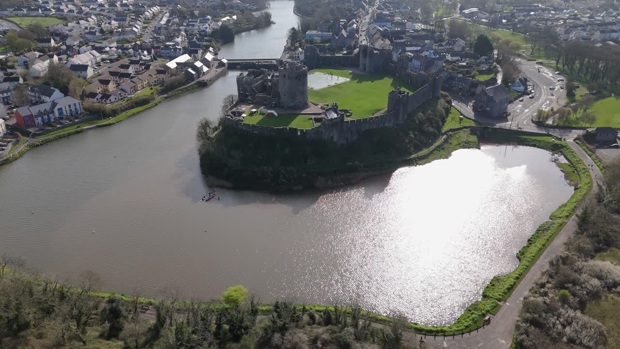 Forward shot of Pembroke Castle with pool and panoramic aerial view of city, Wales UK