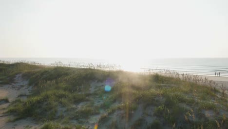 4K-Ansicht-Des-Strandzugangs,-Der-Sich-über-Die-Dünen-Erhebt-Und-Bei-Sonnenaufgang-Den-Blick-Auf-Das-Meer-Mit-Blendenfleck-Freigibt