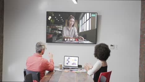 Diverse-business-people-on-video-call-with-caucasian-female-colleague-on-screen