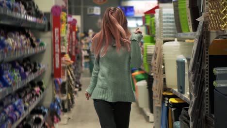 woman funny dances in supermarket between the rows