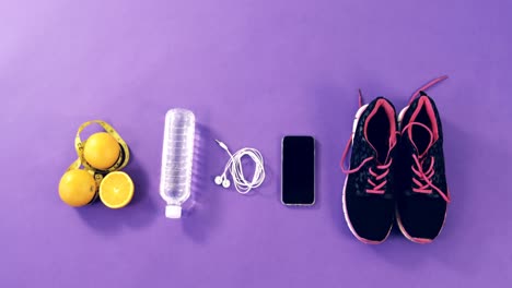 mobile phone with headphones, shoes, water bottle, lemon and measuring tape