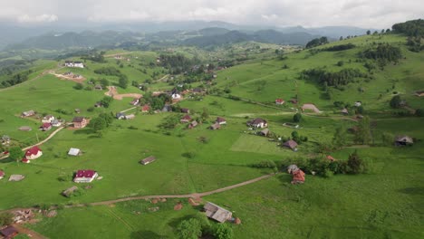 Colinas-Y-Pueblos-Pintorescos-En-Medio-De-Una-Exuberante-Vegetación,-Bajo-Un-Cielo-Parcialmente-Nublado,-Vista-Aérea