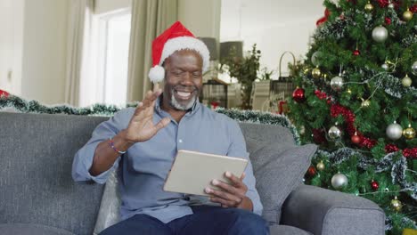 Happy-senior-african-american-man-using-tablet-at-christmas