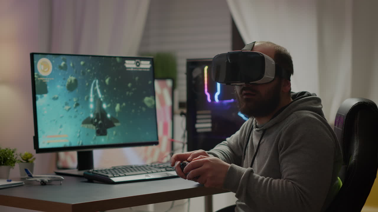 Videogame player with VR headset raising hands after winning space shooter