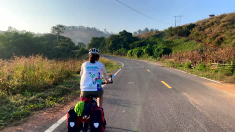 women cycling in the sunset road of nan province, thailand