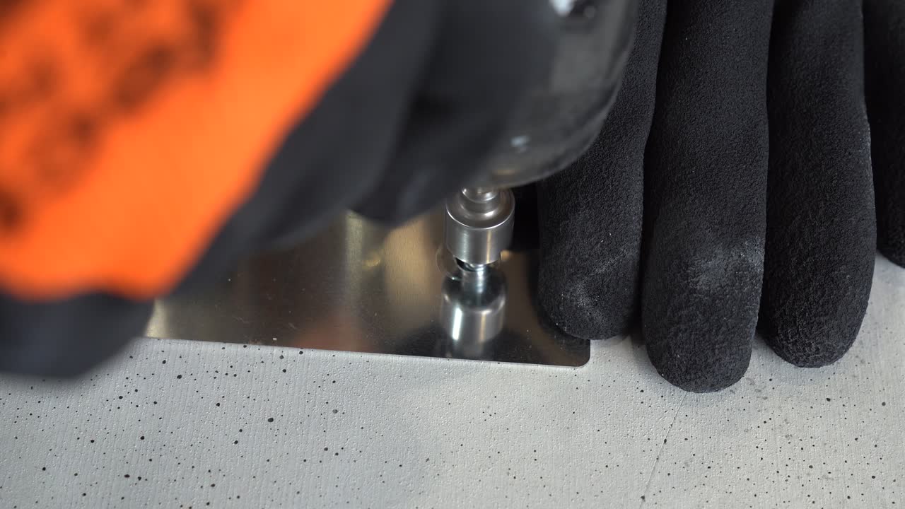 Close up of a man fastening a metal plate with a screw