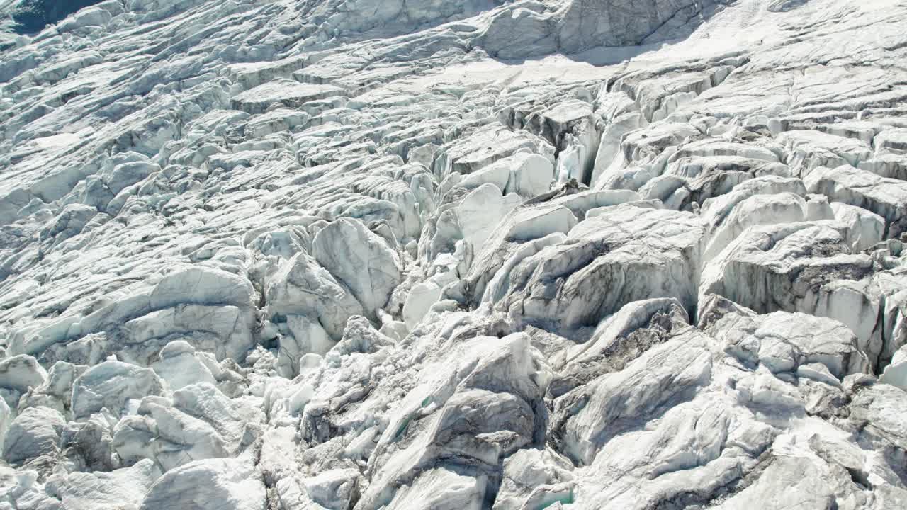 vuelo aéreo cercano sobre el glaciar de hielo con profundas grietas y grietas, sobrevuelo aéreo de allalingletscher suiza