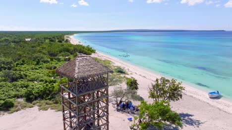 wooden observation tower on exotic tropical sand beach, aerial forward