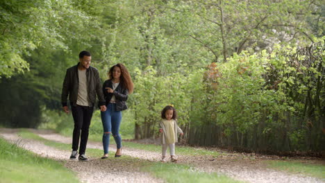 couple talk during a country walk with their young daughter