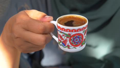 una mujer sostiene una taza de café turco