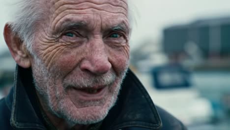 elderly man reflects on life while enjoying the tranquility of a harbor on a cloudy day