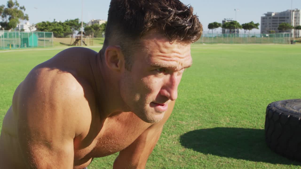 웃고 셔츠 없는 백인 남자가 야외 운동 후 회복하고 있습니다.