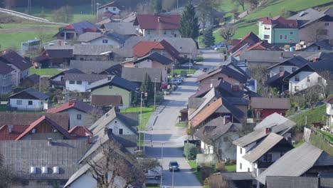 Top-view-of-village-and-single-car-drive-through