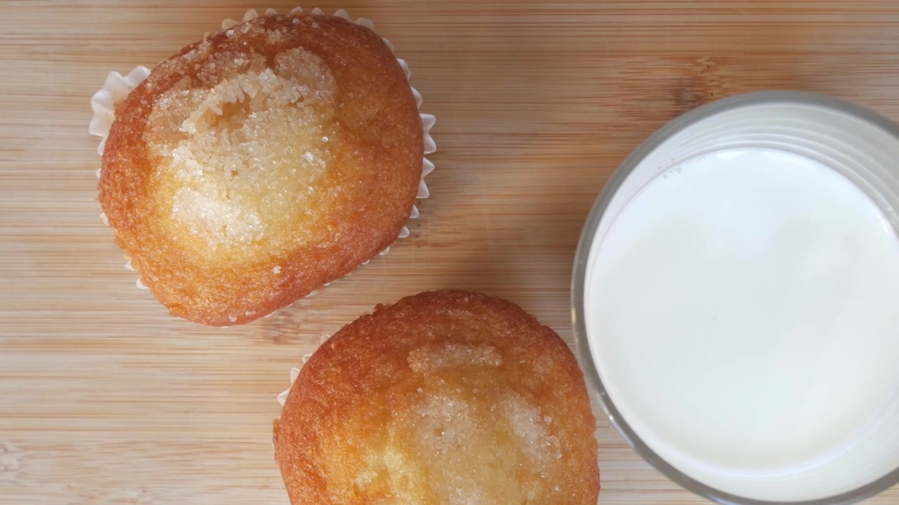 Deliziosi muffin con glassa di zucchero su un tagliere di legno in un'atmosfera accogliente.