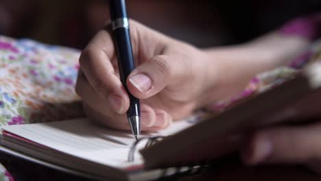 woman's hand writing in notebook