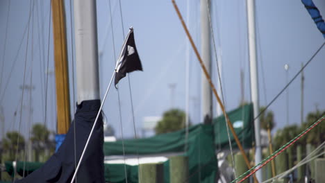 schwarze segelflagge mit totenkopf und gekreuzten knochen, die im wind fliegen