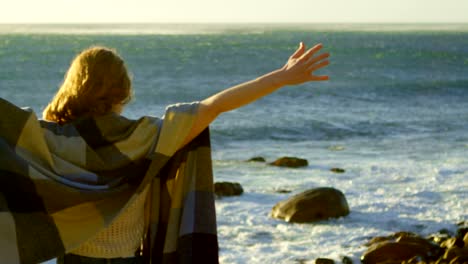 woman standing with arms outstretched near a sea 4k