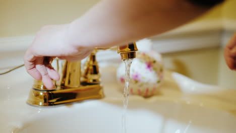 A-Man-Washes-His-Hands-Under-A-Tap-With-Water