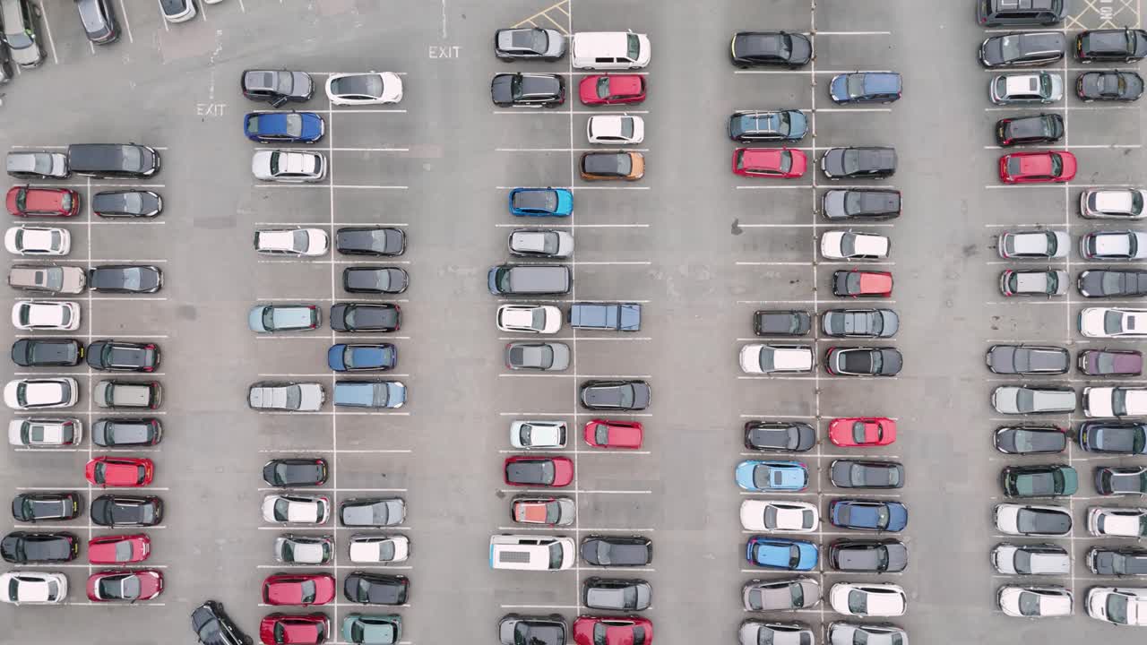 영국 주차장에 주차된 차량의 상단에서 아래로 공중 뷰, 조직 된 줄과 다양한 차량을 보여줍니다.