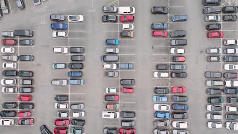 Top-down-aerial-view-of-cars-parked-in-a-UK-carpark,-showcasing-organized-rows-and-diverse-vehicles