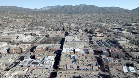 Downtown-Santa-Fe,-New-Mexico-and-mountains-with-drone-video-wide-shot-moving-in-a-circle