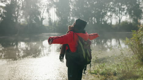 Woman-at-river,-stretching-arms