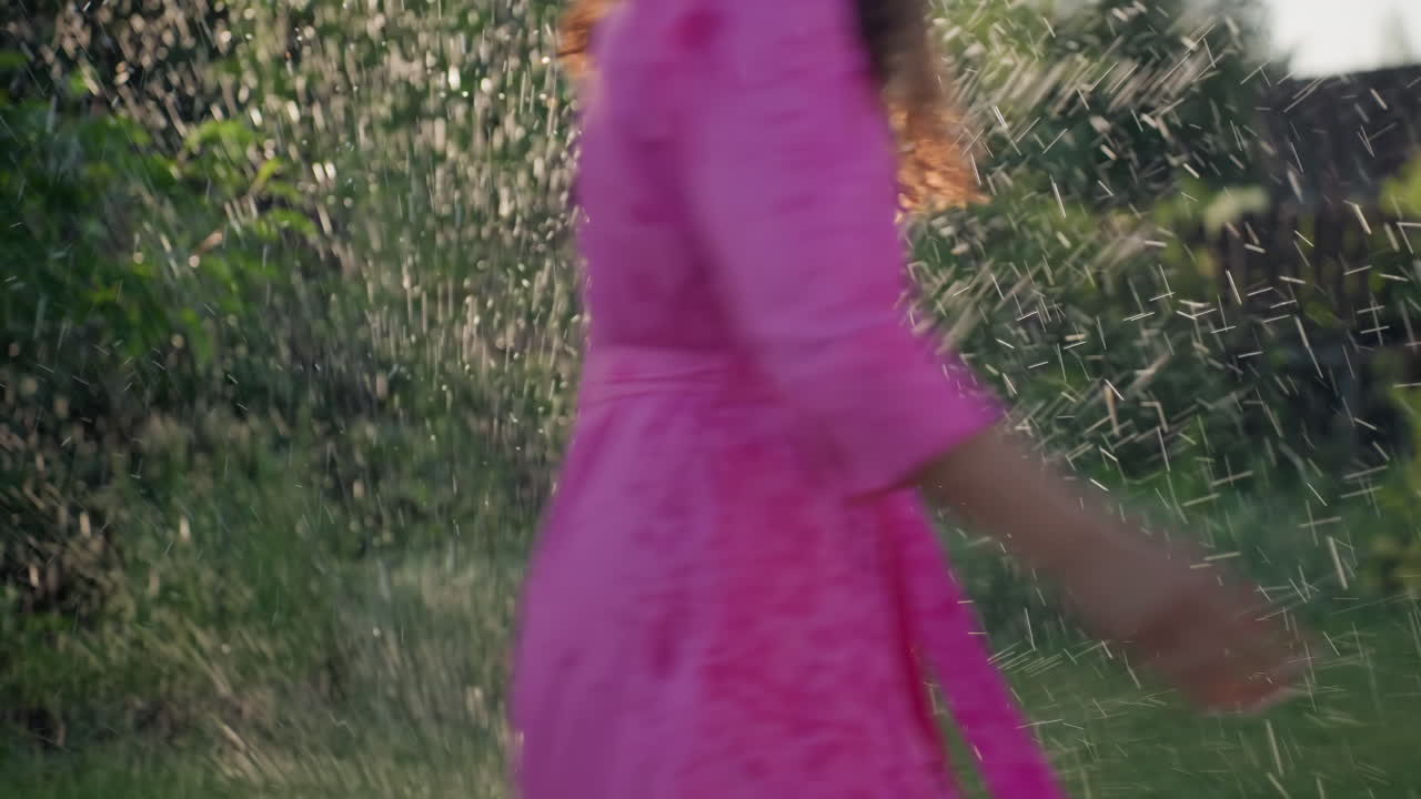 Girl Splashes Water Happily Outside, Little Girl Enjoys Outdoor Fun And Water Splashing On Sunny Day, Young Child Has Happy Outdoor Playtime During Summer With Water Splashing Excitement