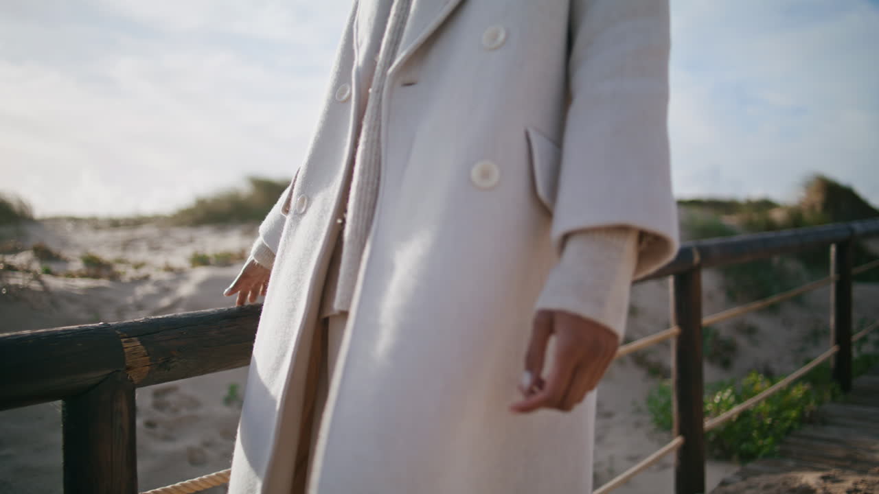 Closeup girl body strolling wooden pier. Calm serene woman touching railings