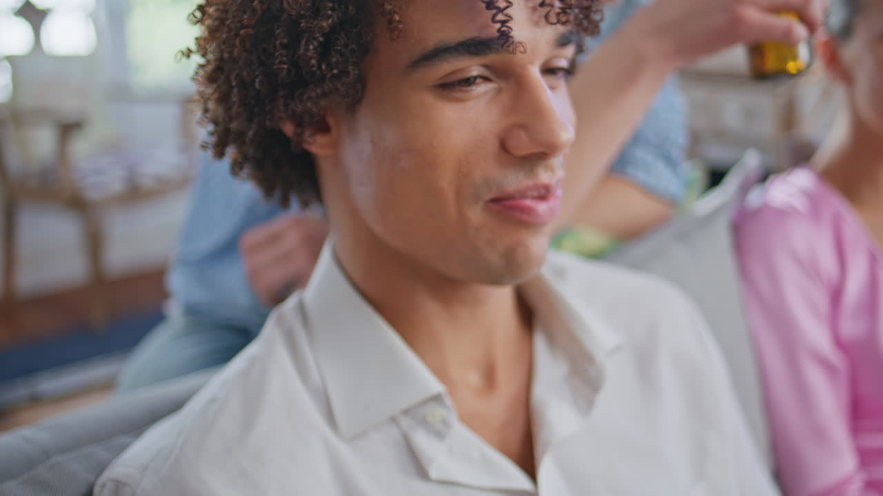 Laughing teenager watching comedy movie at home closeup. People drinking beer