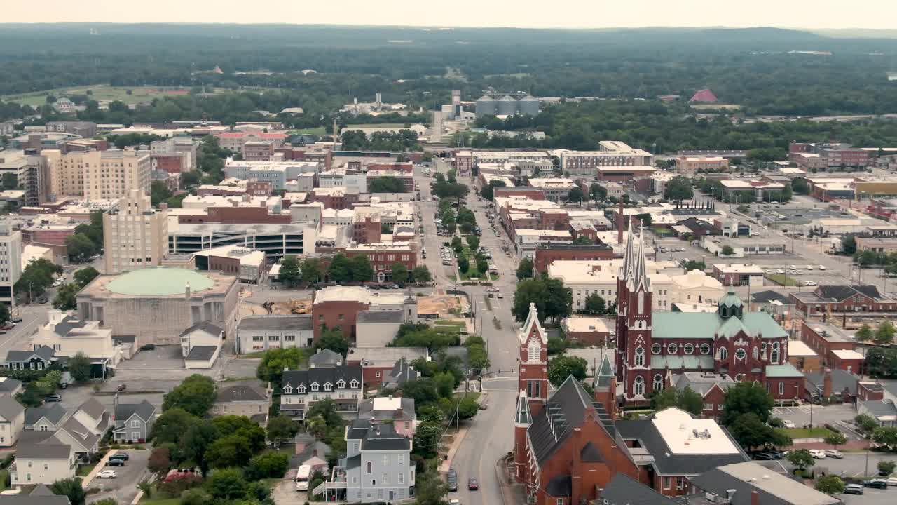 An aerial shot of downtown Macon, GA, with views of the St. Joseph church, Poplar Street, and the forests in the distance