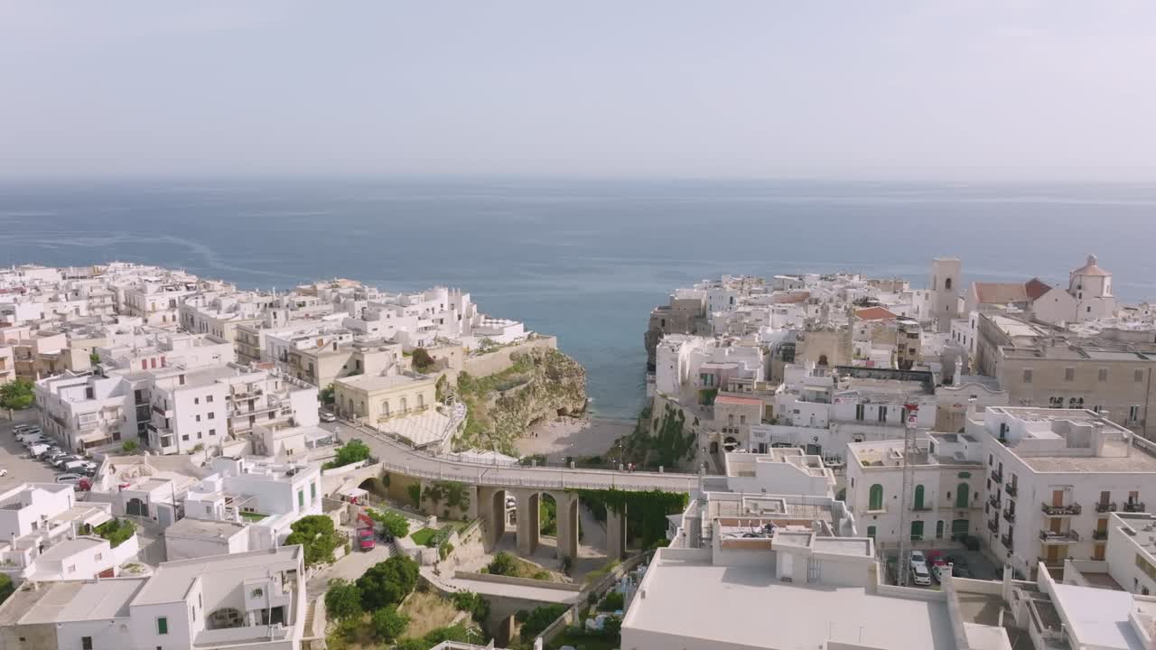imágenes aéreas girando alrededor del puente y la playa en polignano a mare, italia.
