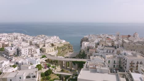 Imágenes-Aéreas-Que-Giran-Alrededor-Del-Puente-Y-La-Playa-En-Polignano-A-Mare,-Italia