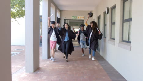 diverse group of graduates celebrates in a high school corridor