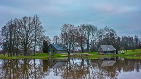 timelapse shot of wooden cottages beside lake throughout the cloudy day during dry autumn day