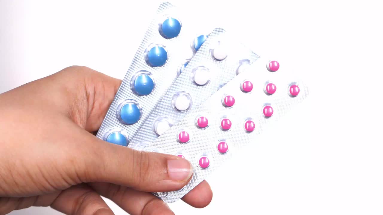 손으로 여러 가지 약을 담은 블리스터 패키지를 들고 있습니다.