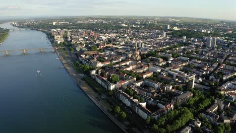 Flying-towards-Mainz-with-a-drone-on-a-sunny-summer-evening-showing-the-old-bridge-and-the-Rhine-river-with-a-boat