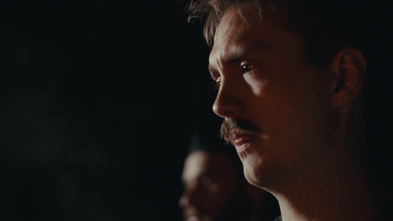 Man with Mustache in Dark Setting