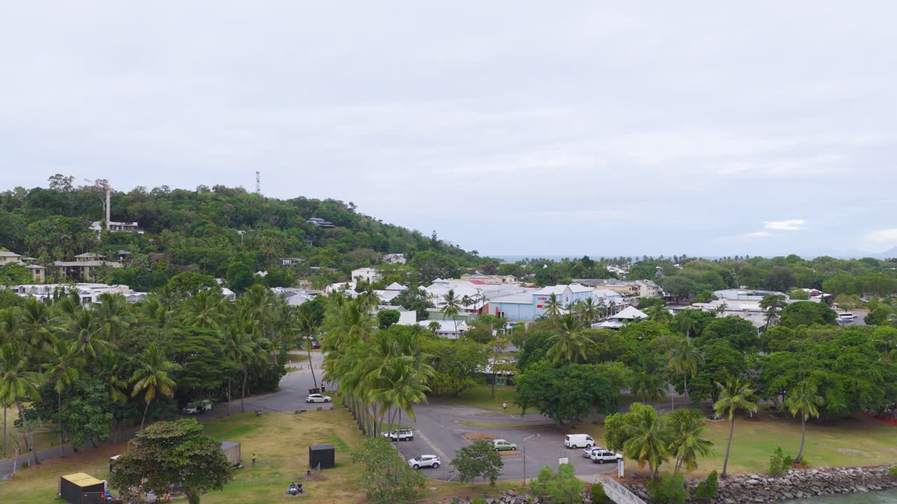 Aerial footage captures lush greenery and urban landscape in Port Douglas, Queensland, under overcast skies