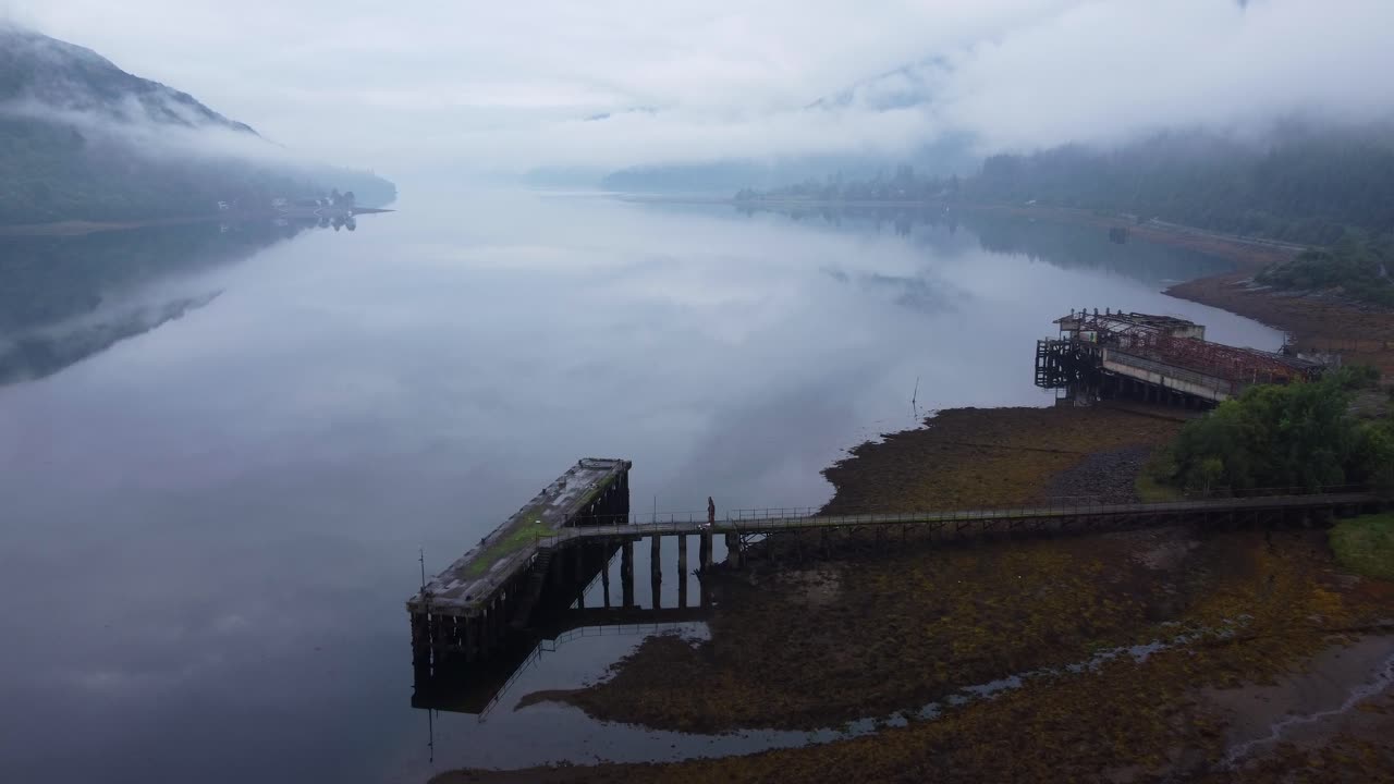 arrochar, 스코틀랜드 고원, 스코틀랜드 서부 해안 근처에 있는 버려진 어뢰 범위 건물 근처의 오래된 부두 - 공중 드론 4k hd 영상, 접근