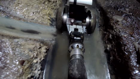 a small inspection camera vehicle is entering a sewage pipe