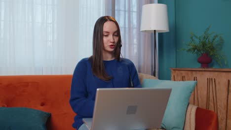 Woman-with-headset-using-laptop,-talking,-working-customer-support-service-operator-at-home-office