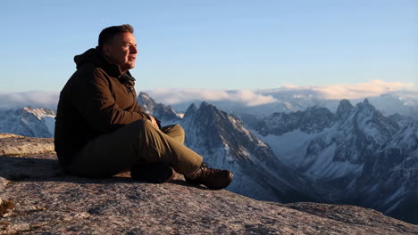man sitting on a mountain overlooking scenic views