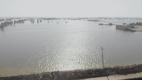 Aerial-Flying-Towards-View-Of-Flooded-Landscape-In-Rural-Jacobabad-On-Bright-Sunny-Day