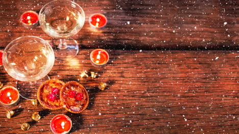 velas y dos vasos en madera combinados con la nieve que cae