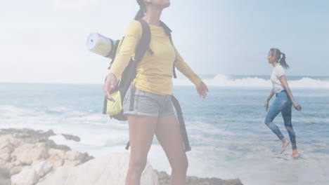 composite of happy african american woman hiking, and dancing in sea at the beach