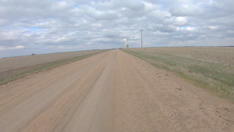 point of view driving on a gravel road and thru and railroad crossing