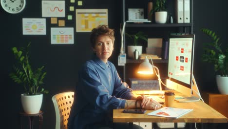 portrait of young businesswoman posing on camera at office desk