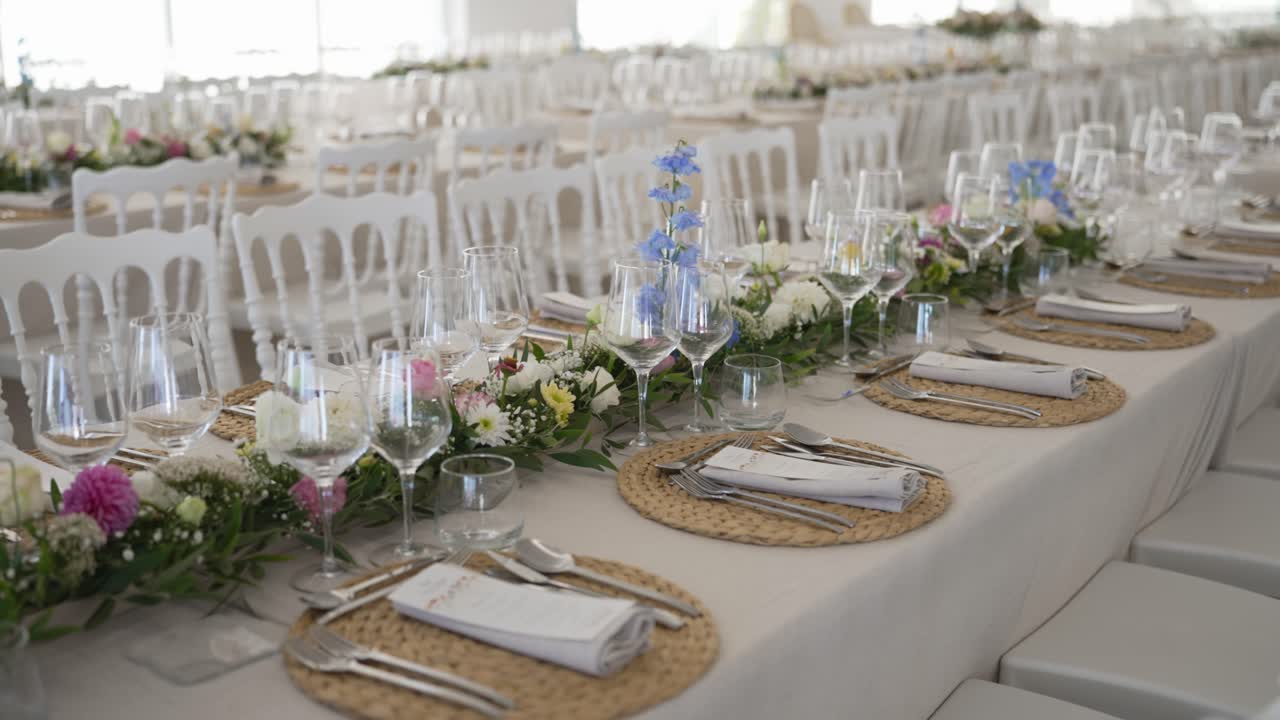 Wedding reception table setting with floral arrangements and wine glasses